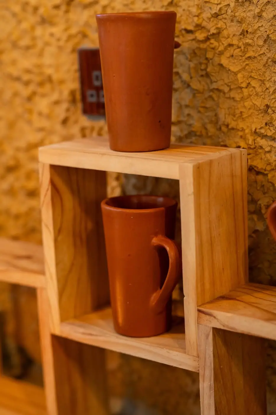 Clay cups on a wooden shelf