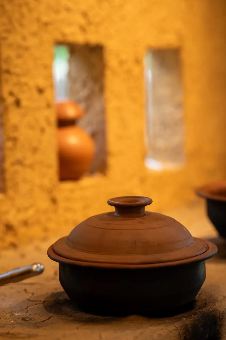 A lidded clay pot on the hearth