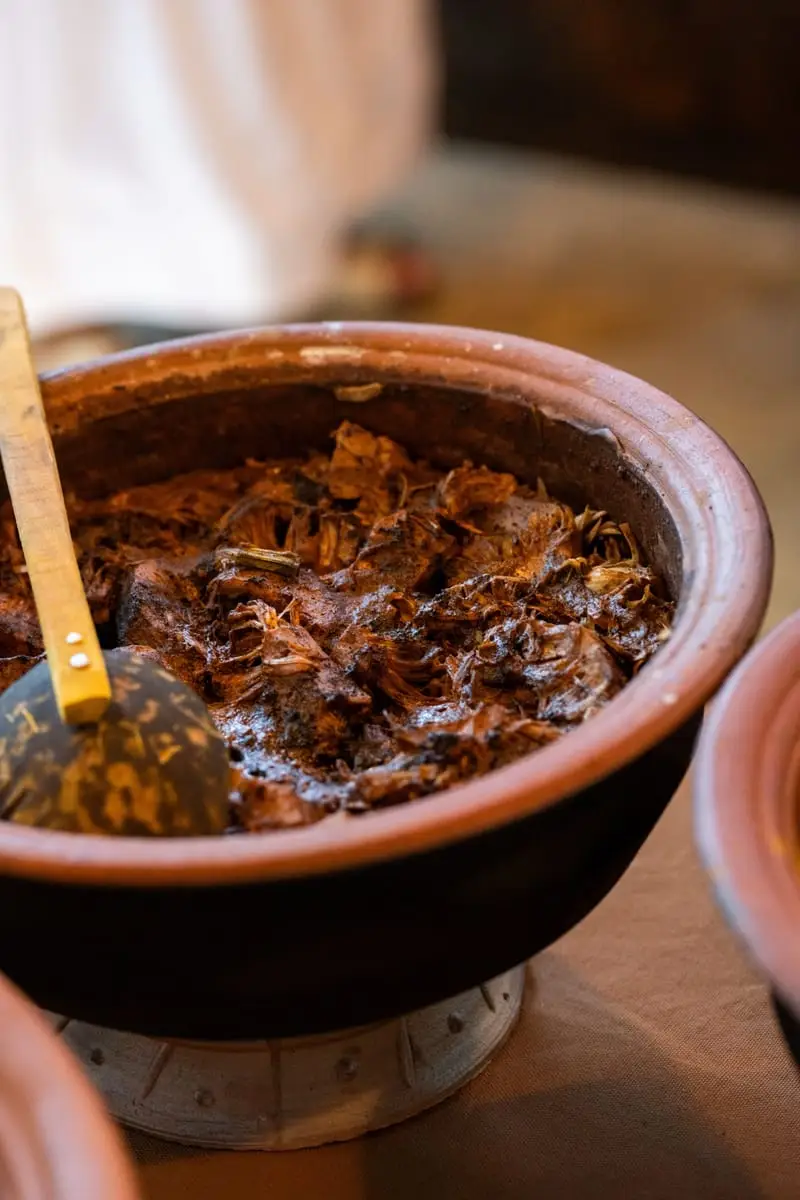 A dark, slow-cooked curry in a clay pot