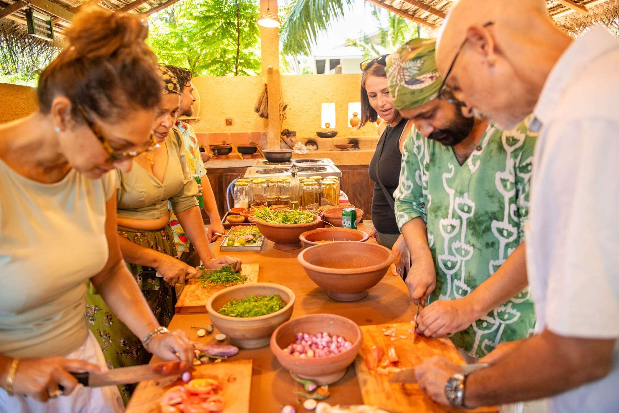 Guests chopping vegetables at the clay kitchen counters with their hosts