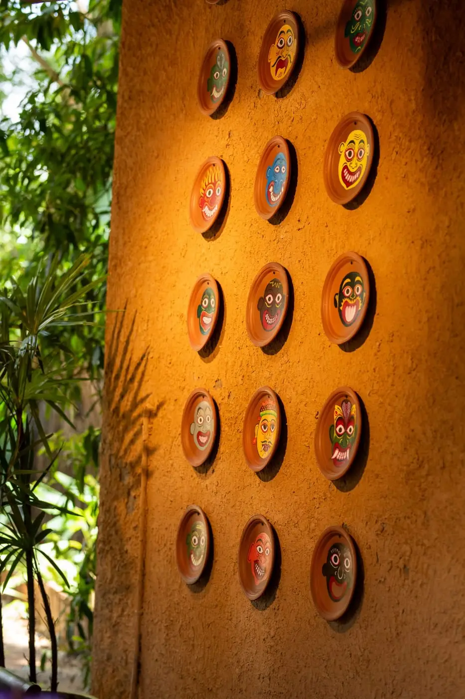 Painted plates set into the clay wall